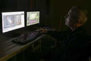 Chris Hill looks at two screens with astrophotography