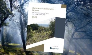An aerial photograph shows a dramatic view of a massive gravel mine rising out of the woods next to a neighborhood and natural scenery - like a tan-colored scar on the land.