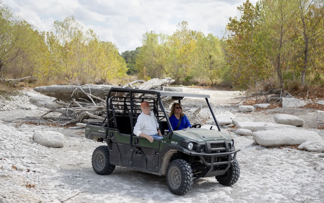 Kathleen Tobin Krueger drives with her brother Patrick Tobin through the dry riverbed of the Medina River near Bandera. Credit: Nick Wagner / San Antonio Report