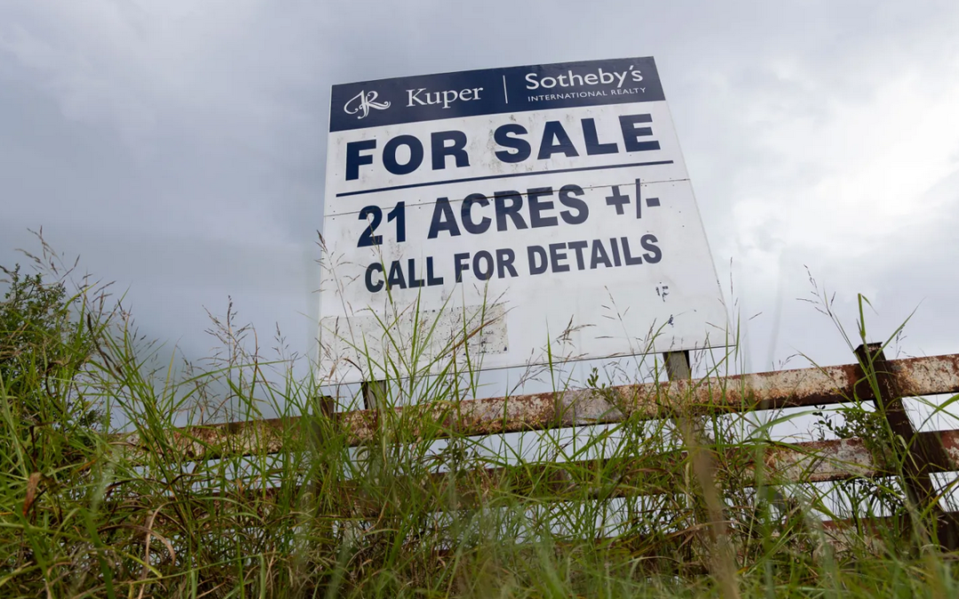 Sign on a fence post advertising 21 acres for sale