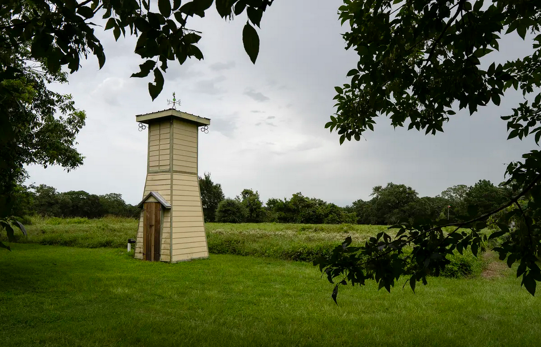 An old pumphouse sits on the edge of a field