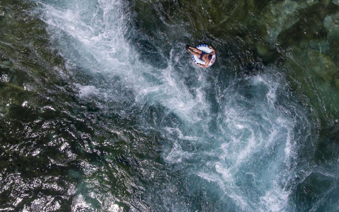A person floating in a tube down small river rapids